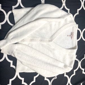 White sweater with buttons. is cropped and is low on the top